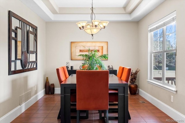 4236 Frederick Cir, Longmont, CO 80503 - dining area featuring a chandelier, tile patterned flooring, a raised ceiling, and baseboards