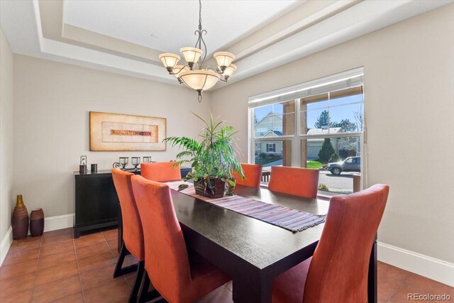 4236 Frederick Cir, Longmont, CO 80503 - tiled dining area featuring a chandelier, baseboards, and a tray ceiling