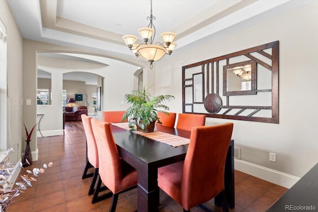 4236 Frederick Cir, Longmont, CO 80503 - tiled dining room featuring arched walkways, a chandelier, a tray ceiling, and baseboards