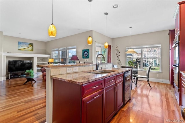 4236 Frederick Cir, Longmont, CO 80503 - kitchen with a sink, reddish brown cabinets, light wood-type flooring, and plenty of natural light