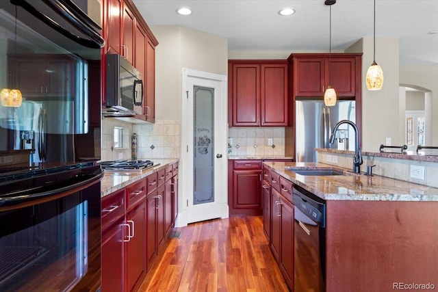 4236 Frederick Cir, Longmont, CO 80503 - kitchen with black appliances, a sink, reddish brown cabinets, light wood finished floors, and recessed lighting