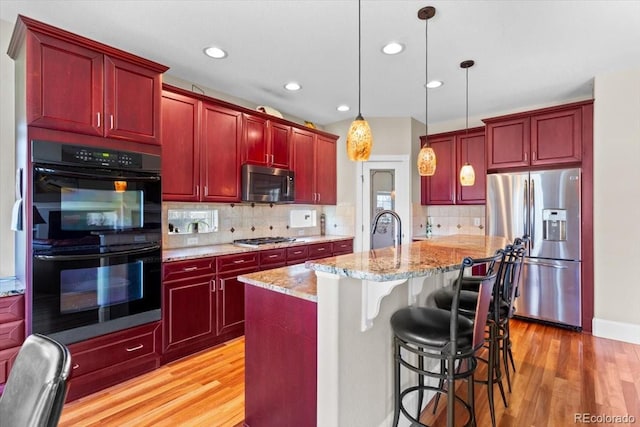 4236 Frederick Cir, Longmont, CO 80503 - kitchen featuring appliances with stainless steel finishes, reddish brown cabinets, light wood finished floors, and recessed lighting