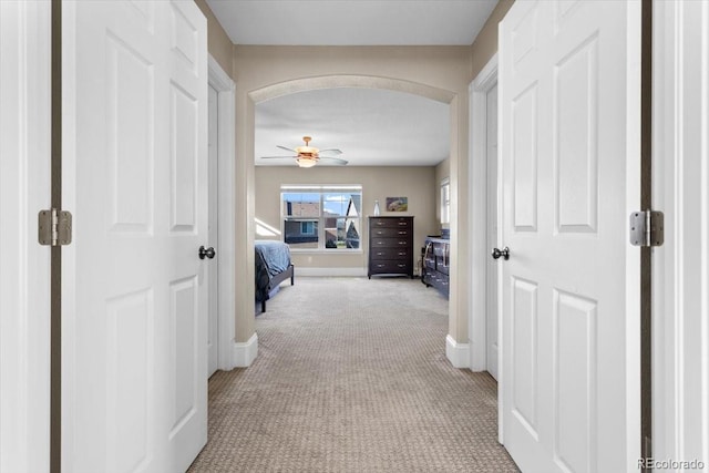 4236 Frederick Cir, Longmont, CO 80503 - hallway featuring light carpet, arched walkways, and baseboards
