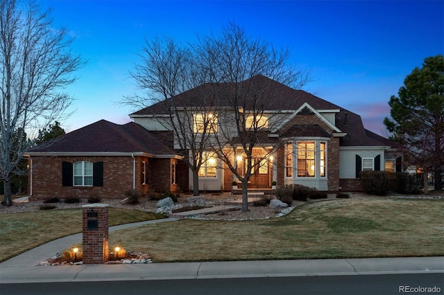 traditional home featuring brick siding and a front lawn