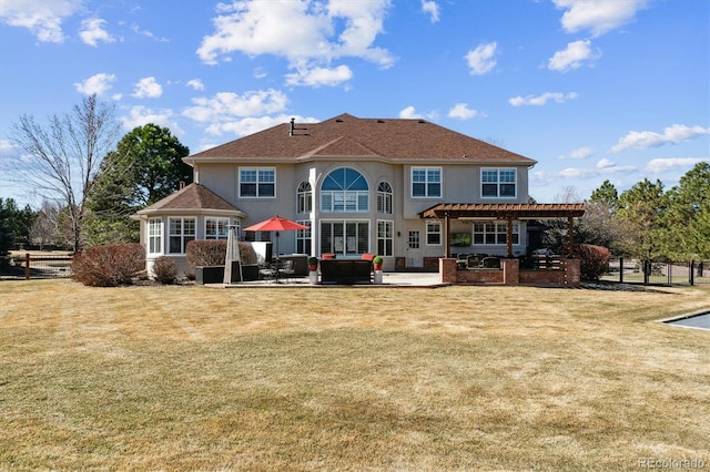 rear view of house with a yard, a patio area, a pergola, and stucco siding