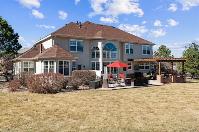 rear view of house featuring fence, a yard, a pergola, stucco siding, and a patio area