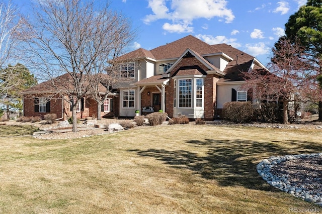 view of front facade with brick siding and a front yard