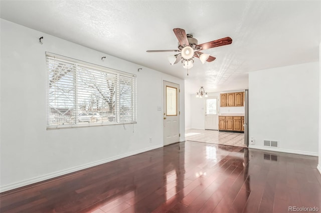 unfurnished living room with light hardwood / wood-style floors, ceiling fan with notable chandelier, and a textured ceiling