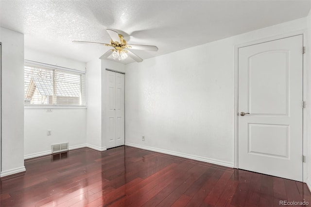 spare room with ceiling fan, a textured ceiling, and dark hardwood / wood-style floors