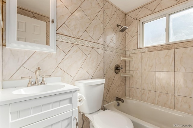 full bathroom featuring tile walls, toilet, vanity, and tiled shower / bath