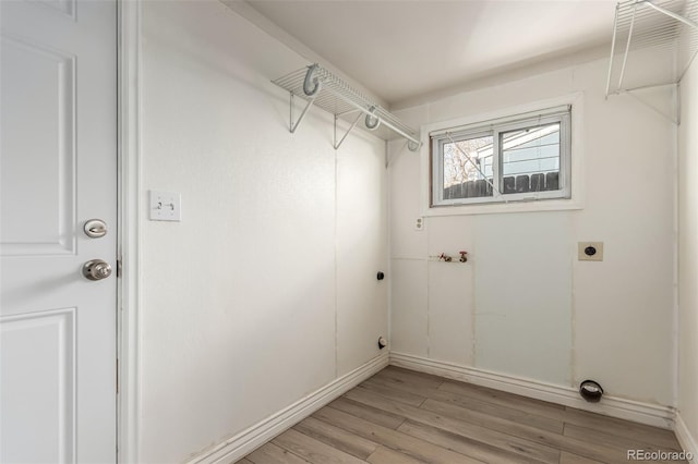 laundry area with hookup for an electric dryer and light wood-type flooring