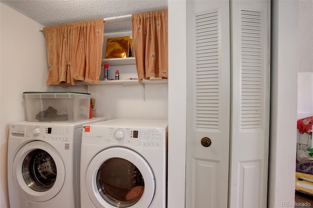 laundry area featuring washing machine and dryer and a textured ceiling