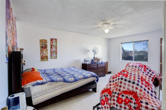 carpeted bedroom with ceiling fan and a textured ceiling