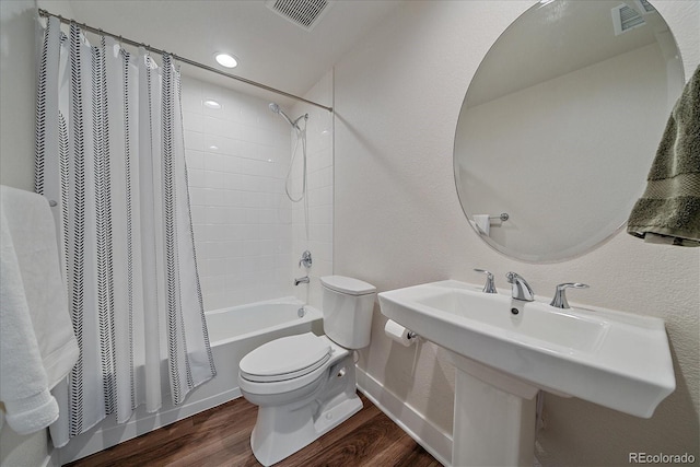 5189 Vivian St, Wheat Ridge, CO 80033 - bathroom featuring toilet, shower / bath combo with shower curtain, wood finished floors, baseboards, and a sink