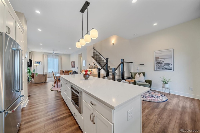 5189 Vivian St, Wheat Ridge, CO 80033 - kitchen with stainless steel appliances, wood finished floors, white cabinetry, and recessed lighting