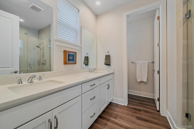 5189 Vivian St, Wheat Ridge, CO 80033 - full bathroom featuring a stall shower, double vanity, and wood finished floors