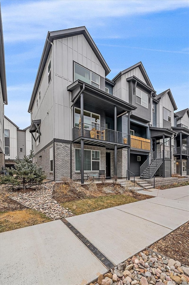5189 Vivian St, Wheat Ridge, CO 80033 - view of front of home featuring board and batten siding, brick siding, and a balcony