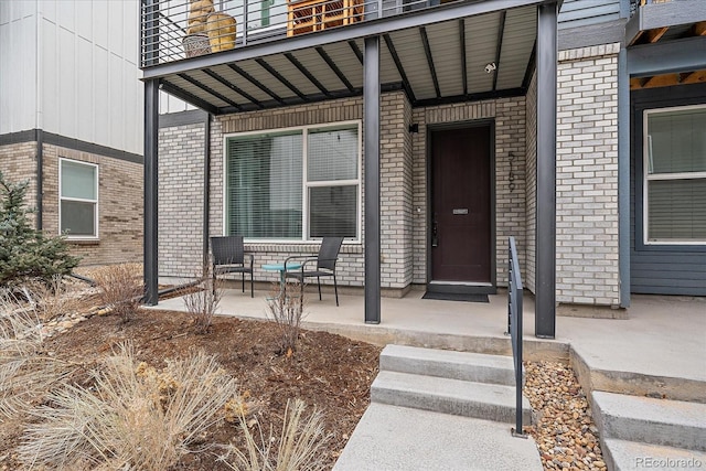 5189 Vivian St, Wheat Ridge, CO 80033 - property entrance with brick siding, a porch, and a balcony