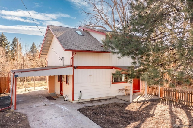 view of front of house featuring roof with shingles and fence