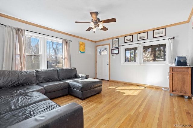 living room with ornamental molding, ceiling fan, baseboards, and wood finished floors