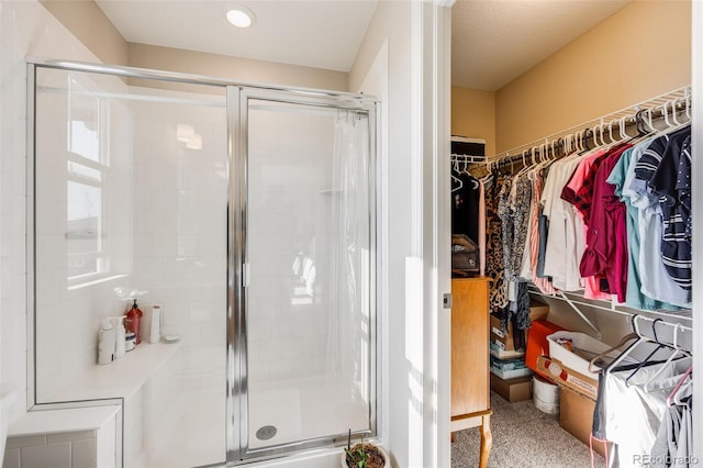 bathroom with a stall shower and a walk in closet
