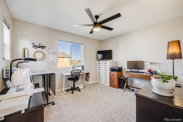 carpeted office space with ceiling fan and baseboards