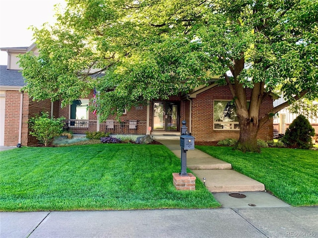 view of front of home with brick siding and a front yard