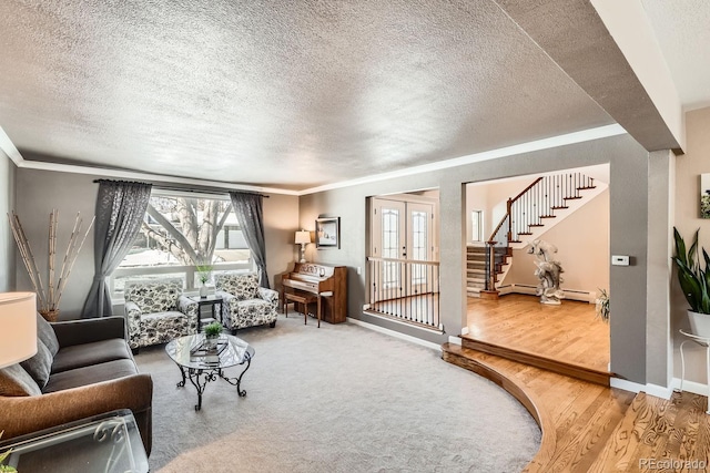 living room with a baseboard heating unit, crown molding, stairway, and baseboards