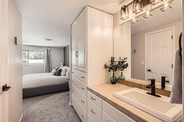 bathroom featuring visible vents, vanity, and ensuite bathroom