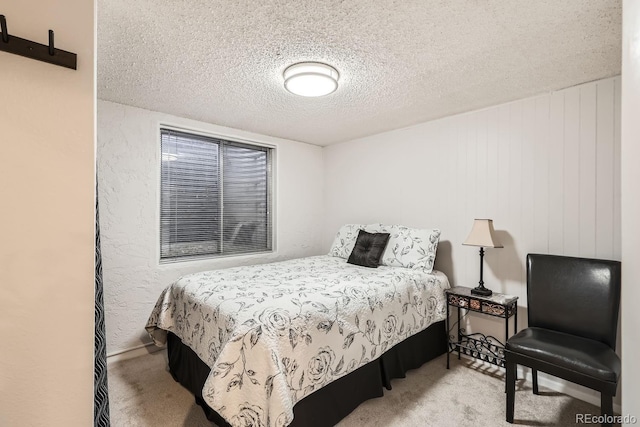 bedroom with light carpet and a textured ceiling