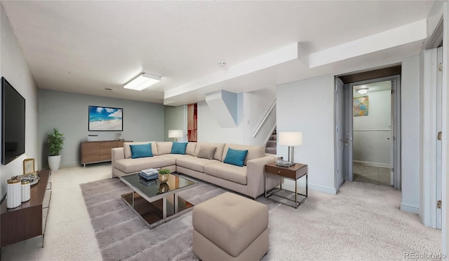 living room with baseboards, stairs, and light colored carpet