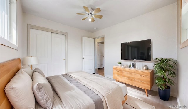 bedroom featuring baseboards, light wood-style floors, and a closet