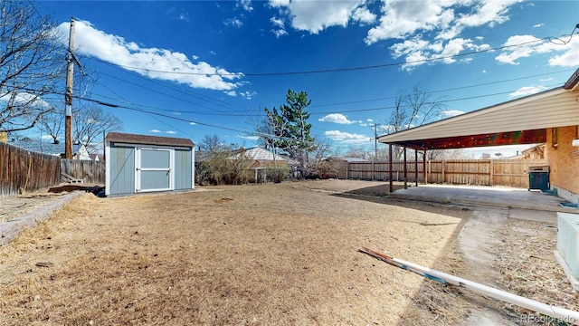 view of yard with a fenced backyard, a patio, an outdoor structure, and a shed