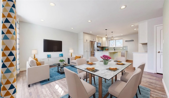 dining space with recessed lighting, light wood finished floors, and baseboards