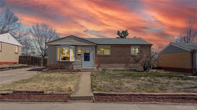 bungalow-style home with fence and a yard