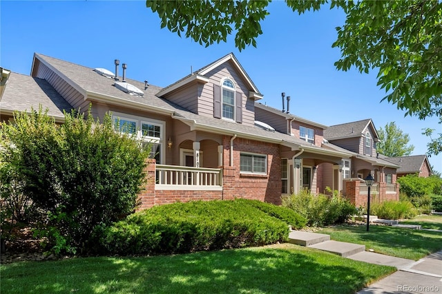 craftsman inspired home with brick siding and a front lawn