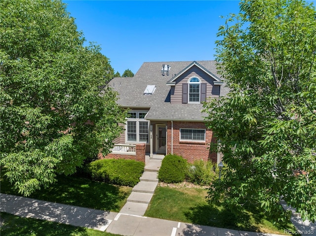 view of front of home with brick siding and a shingled roof