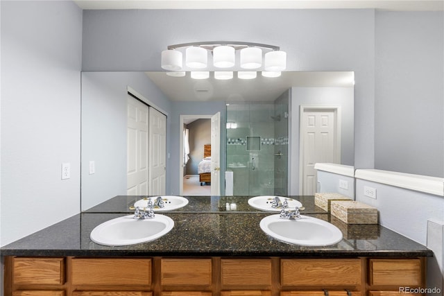 ensuite bathroom with double vanity, a stall shower, ensuite bathroom, and a sink