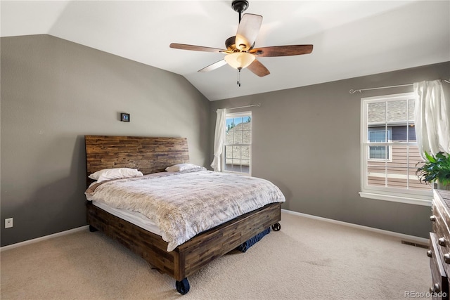 bedroom featuring light carpet, a ceiling fan, baseboards, and vaulted ceiling