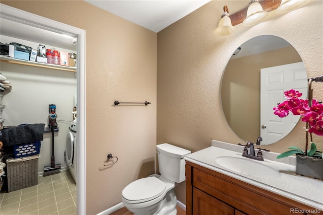 bathroom with vanity, washer / dryer, tile patterned flooring, toilet, and a textured wall