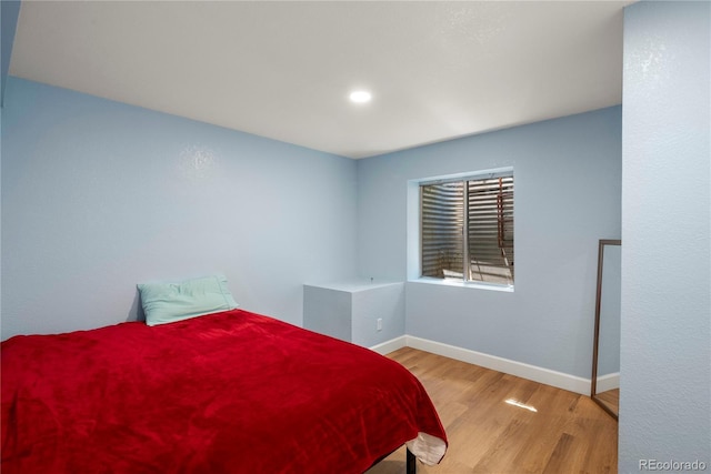 bedroom with baseboards and wood finished floors