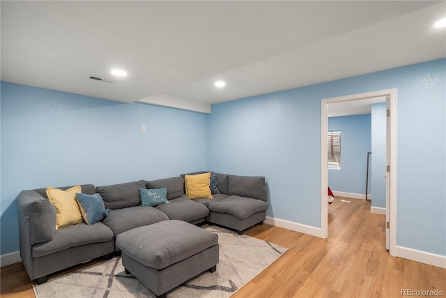 living area with visible vents, baseboards, and light wood finished floors