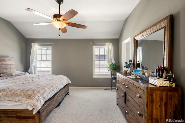 bedroom with light carpet, ceiling fan, baseboards, and vaulted ceiling