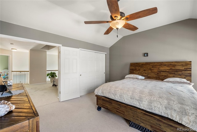 bedroom featuring a ceiling fan, lofted ceiling, light colored carpet, and a closet