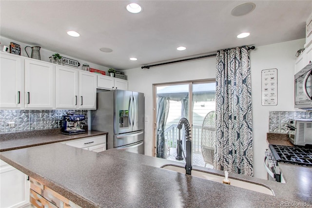 21418 E Stroll Ave, Parker, CO 80138 - kitchen with stainless steel appliances, dark countertops, white cabinets, tasteful backsplash, and recessed lighting