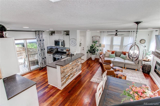 21418 E Stroll Ave, Parker, CO 80138 - living room featuring dark wood-type flooring, a textured ceiling, and ceiling fan