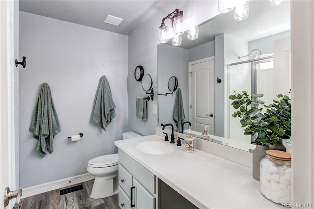 21418 E Stroll Ave, Parker, CO 80138 - full bath featuring toilet, baseboards, a stall shower, vanity, and wood finished floors