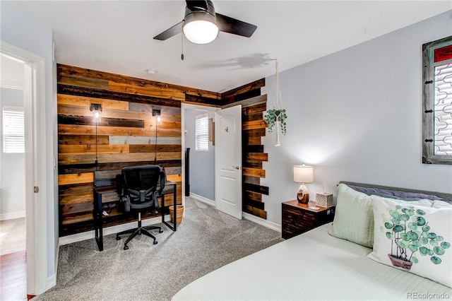 21418 E Stroll Ave, Parker, CO 80138 - carpeted bedroom featuring wood walls, an office area, baseboards, and ceiling fan