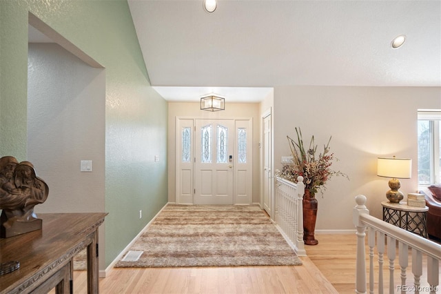 entrance foyer with visible vents, wood finished floors, and baseboards