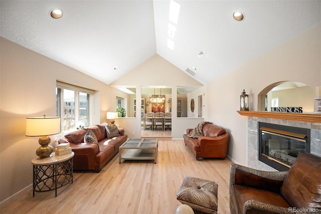 living area with wood finished floors, baseboards, visible vents, recessed lighting, and a tile fireplace